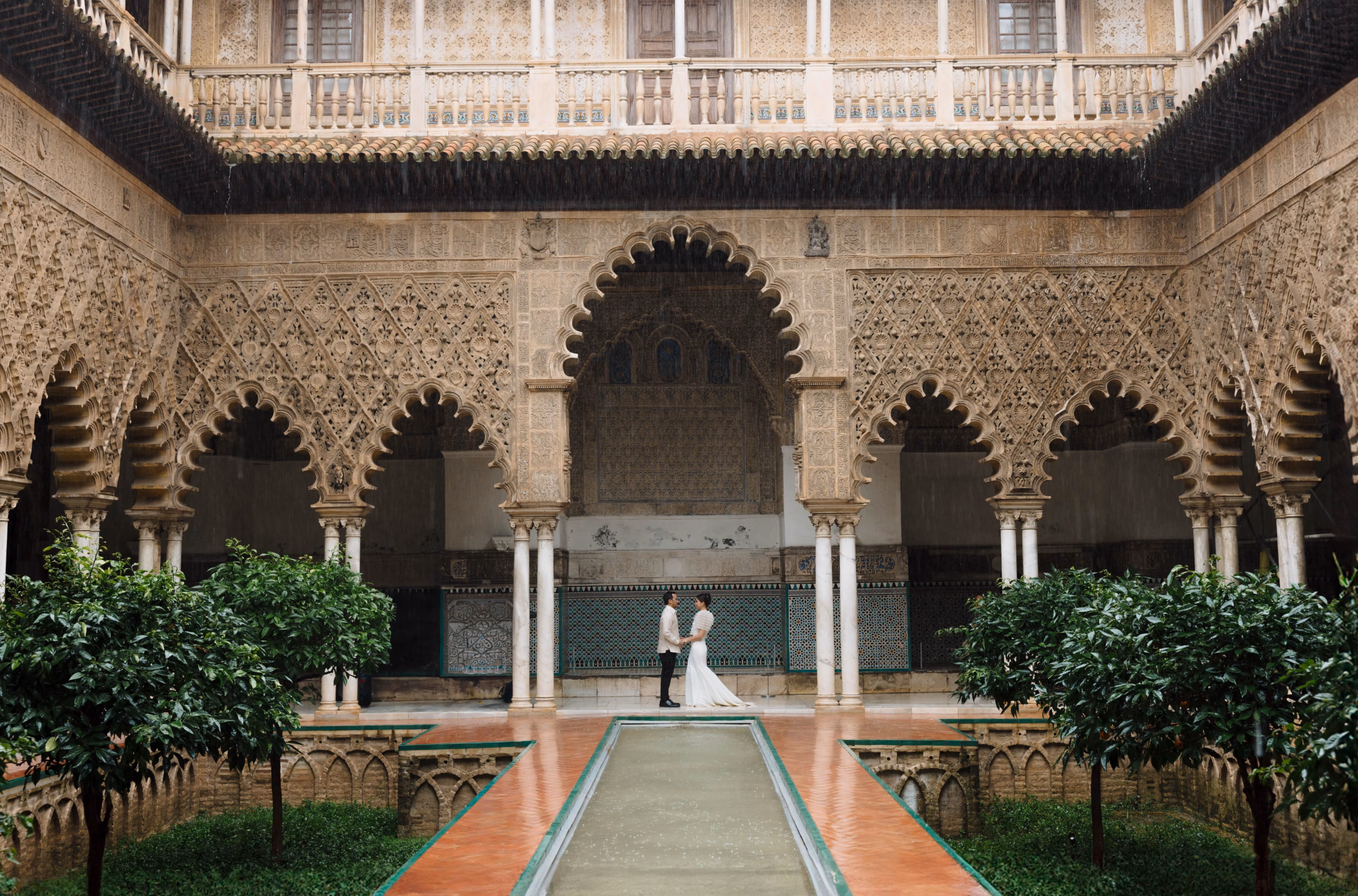 International couple at a historic palace during a luxury destination wedding in Seville, South Spain