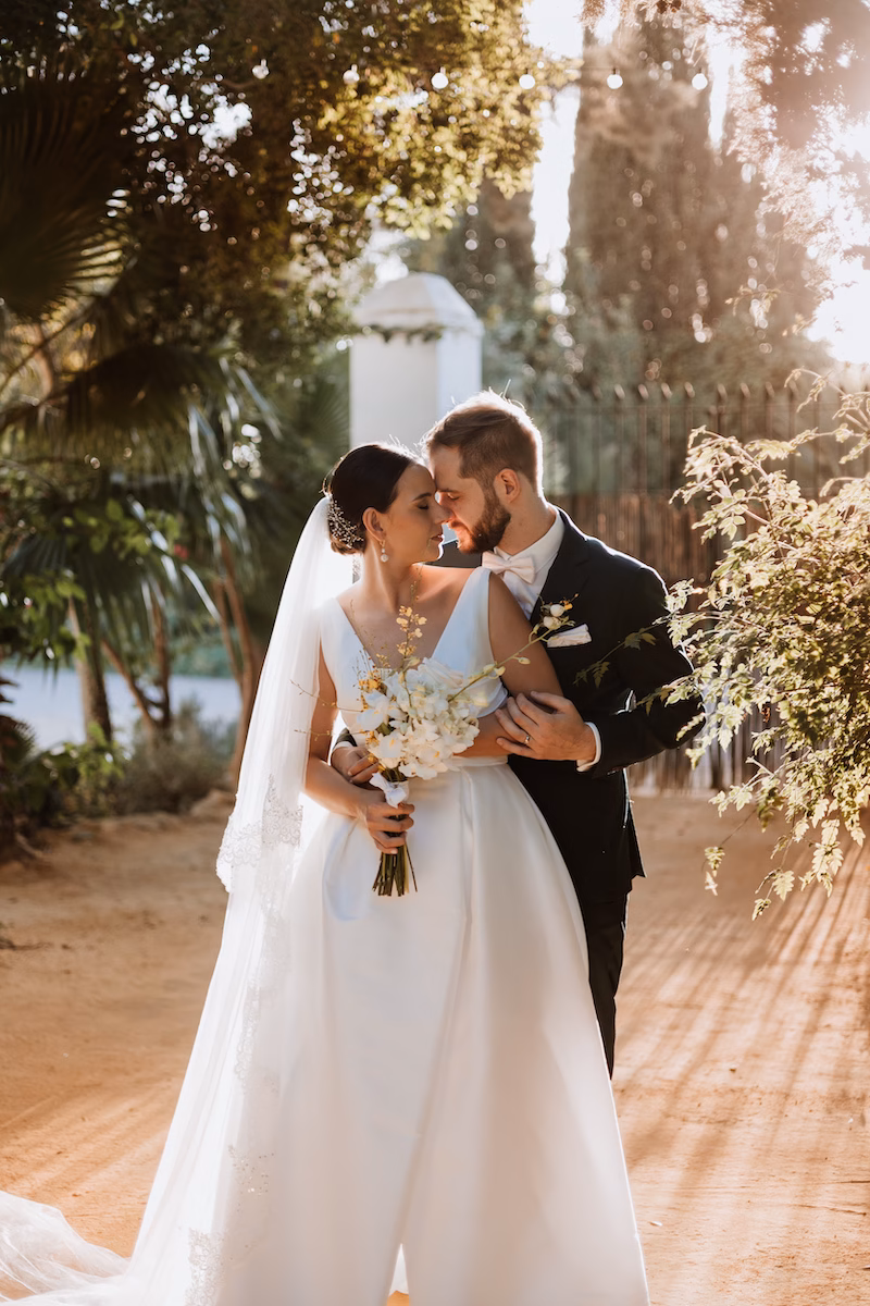 Bride and groom posing in the romantic gardens of an Andalusian estate in Seville.