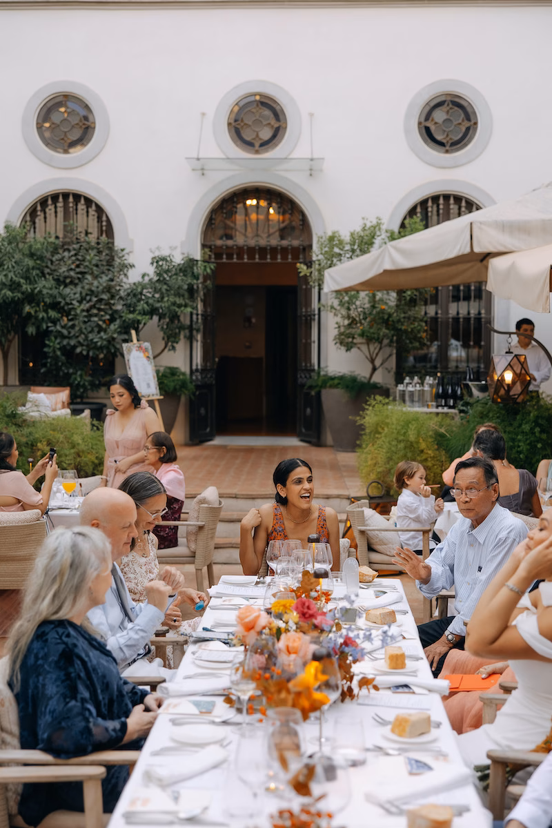 Invitados cenando en el patio de Palacio Villapanés en Sevilla al atardecer