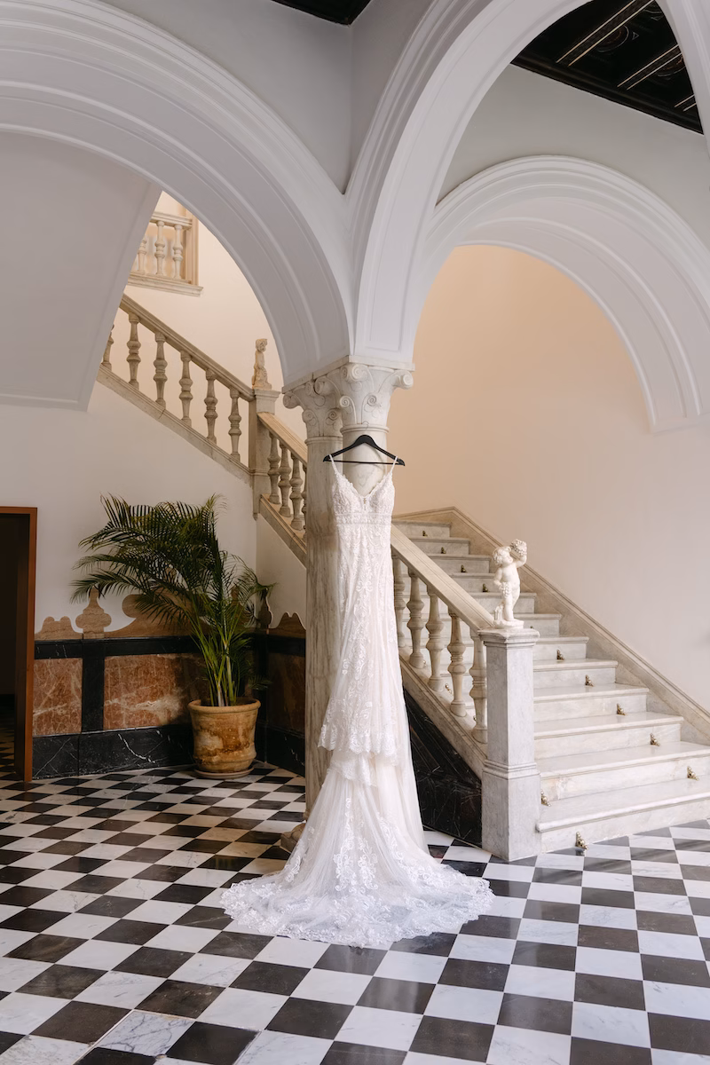 wedding dress hanging in seville palace staircase spain. Intimate and romantic destination wedding in Seville.
