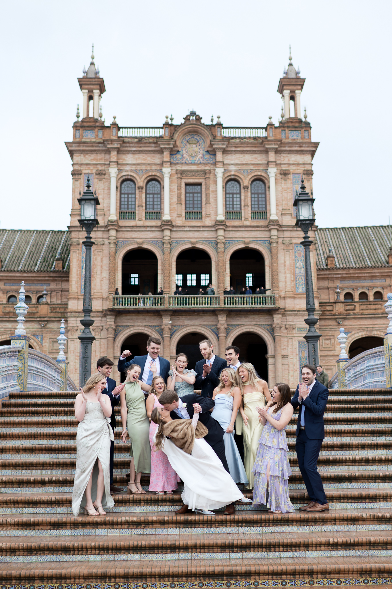 Bride and groom celebrating with wedding guests at Plaza de España during a destination wedding in Seville Spain